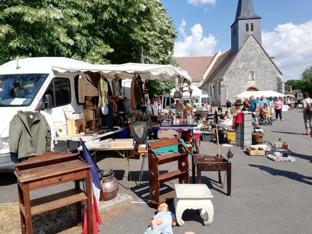 Place avec des brocanteurs et un église au fond